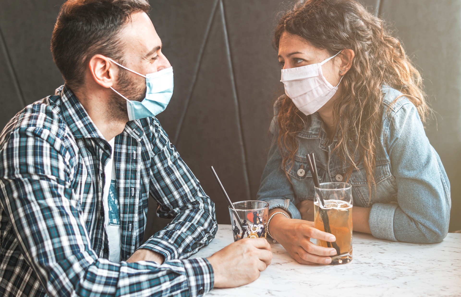 Couple in a restaurant drinking fountain beverages in masks