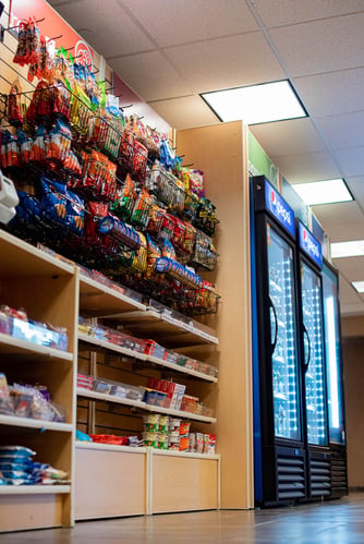 low side angle view of a micro market - shelving for chips and candy with coolers in the background