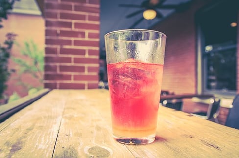 cup on an outdoor table full of a red drink