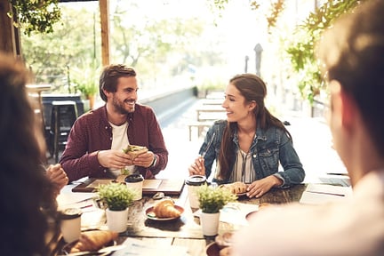 Employees eating sandwiches and drinking coffee