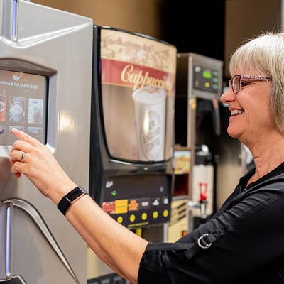 Woman selecting options from a hot beverage machine